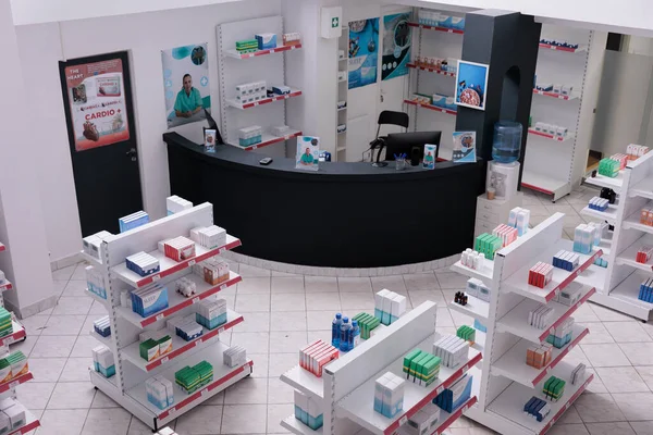 stock image Empty pharmacy with nobody in it having shevles with pharmaceutical products, vitamin, supplements. Drugstore desk full with medical prescription of customers. Medicine support services