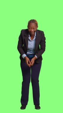 Dikey video: Ofis yöneticisi esniyor ve kendini iş yerinde yorgun hissediyor, yeşil ekranda duruyor. Yorgun çalışan uyuyakalıyor ve tüm vücudundan bezmiş, uykulu yetişkin gibi davranıyor..