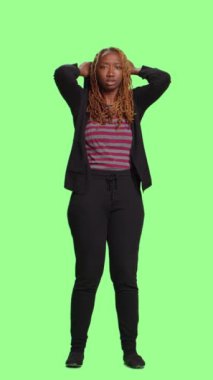 Dikey video: Kadın model tüm yeşil ekranla korkmuş ve endişeli davranıyor, korkuyla ve korkuyla duruyor. Korkmuş ve yeni olmak, duygusal panik tepkisi.