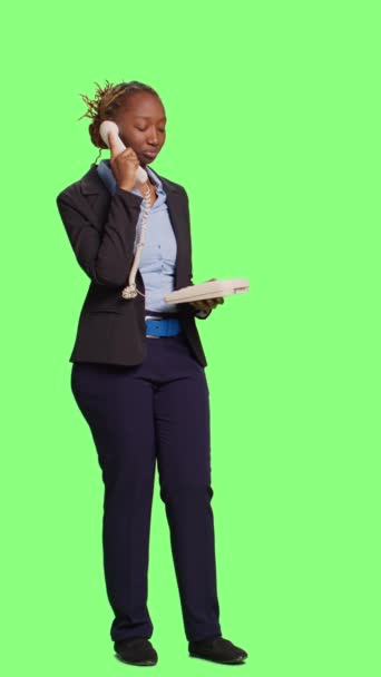 垂直视频 公司员工在工作室通过固定电话交谈 在全身绿屏背景下用电线接听办公室电话 商业女性在背景上表现得很友善 — 图库视频影像