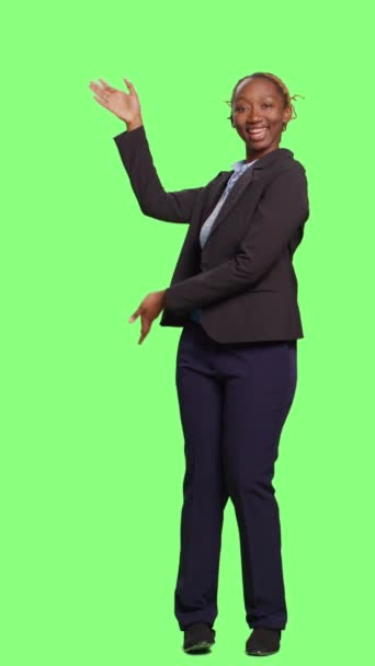 垂直视频 非裔美国人办公室工作人员在全身背景下做绿色屏幕广告 女企业经营者在工作室的绿色屏幕上展示广告范例和促销 微笑着的女孩 — 图库视频影像