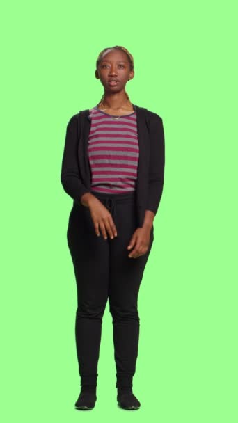 垂直ビデオ ホログラフィック画像と人工知能を使用して 緑の背景に3Dホログラムを見て現代の女性 隔離された緑の画面上に立って完全な体を持つ女性モデル — ストック動画