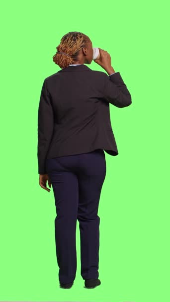 垂直视频 公司经理在工作室提供一杯咖啡 穿着西服 全身绿色屏幕背景 关于女商人享受饮料或点心 有公司办公室工作的回顾 — 图库视频影像