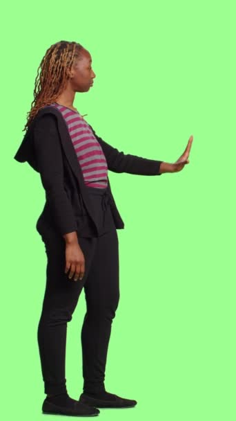 垂直ビデオ 緑の背景の上に手のひらを保持負の女性 拒絶反応と拒否サインをポーズ女性のフルボディ ジェスチャー 否定的な否定 禁止されたシンボルを話すのを止める — ストック動画