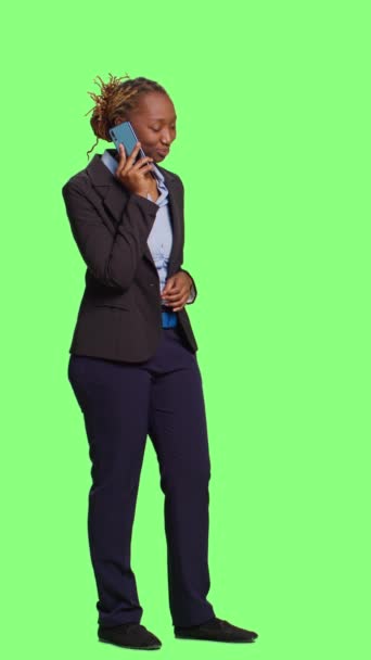 垂直视频 办公室工作人员在智能手机上接听电话 全身上下站在绿色屏幕的背景上 有远程交谈 工作室背景的手机女模特 — 图库视频影像