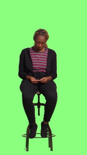 垂直视频 现代年轻人坐在椅子上等待绿色屏幕背景 全身绿色屏幕背景 在演播室里坐着准备 等待和坐着准备 — 图库视频影像