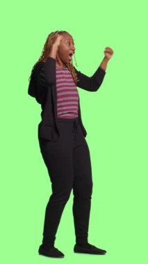 Dikey video: Neşeli mutlu yetişkin yeşil perde arkaplanı üzerinde pozitif, tüm vücut yeşil ekranda. İyimser kadın tezahürat yapıyor, destekliyor, neşeli ve özgüvenli oluyor..