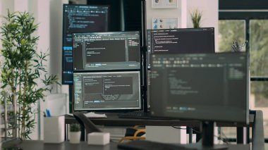 Bilgisayar ekranları boş veri odasında program kodu ve algoritmaları göstererek yeni kullanıcı arayüzü geliştiriyor. Ofisinde bulut hesaplama betiği bulunan Ajans ağ sunucuları.