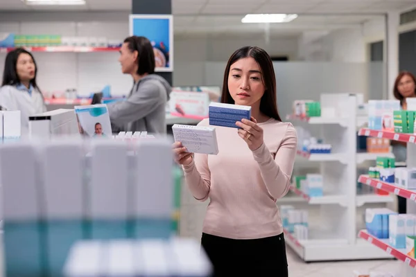Persona Asiática Examinando Cajas Vitaminas Dispersas Los Estantes Farmacia Busca — Foto de Stock