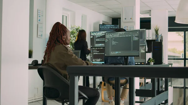 アフリカ系アメリカ人のプログラマーがコンピュータ上にソースコードを入力して新しいユーザーインターフェイスを作成します ターミナル ウィンドウ上のセキュリティ サーバーを開発するために ソフトウェア エンジニアはHtml言語でデータを書きます — ストック写真