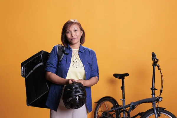 Stüdyoda Termal Teslimat Çantası Taşıyan Yaşlı Teslimatçı Kadın Sarı Arka — Stok fotoğraf