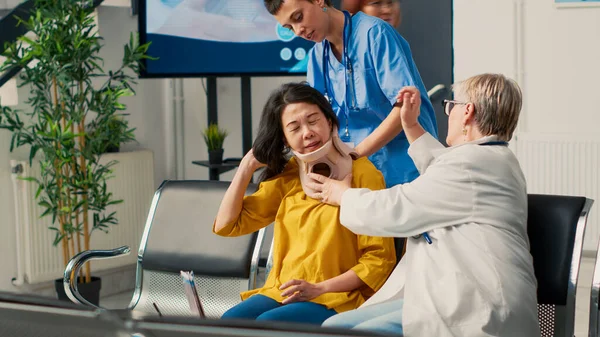 亚洲妇女在医生和护士的帮助下摘除医疗颈领子 并得到专家的帮助 佩戴颈椎支架 在意外受伤后康复 在健康中心进行检查 — 图库照片