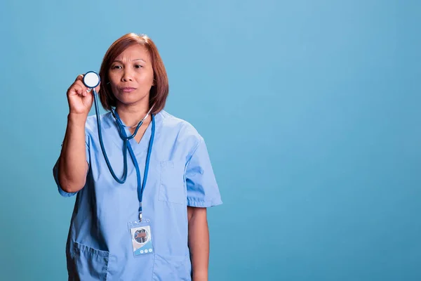 Azjatycki Asystent Medyczny Noszący Niebieski Mundur Podczas Wizyty Kontrolnej Trzymający — Zdjęcie stockowe