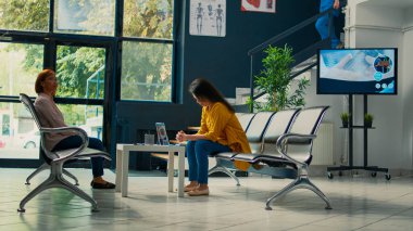 Yaşlı bir hastayı tıbbi randevuya götüren kadın hemşire, hastalıklı bir kadına yardım etmek için sağlık muayenesine başlıyor. Sağlık merkezinin bekleme salonunda biri var. Üçayak atışı.