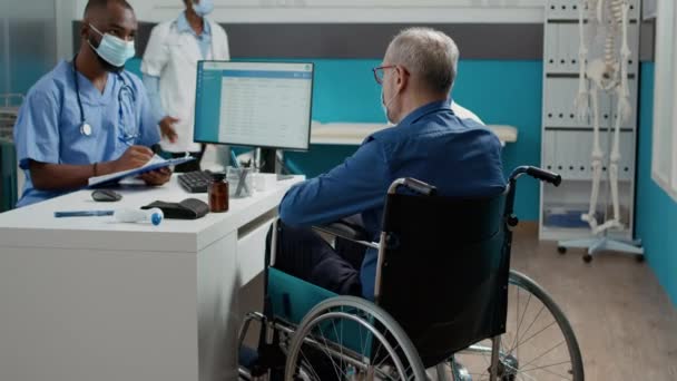 Specialist Taking Notes Checkup Man Wheelchair Wife Consulting Old Patient — Stock Video