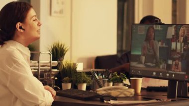 Ofis çalışanı web kamerasındaki insanlarla konuşmak için bilgisayar üzerinden video görüşmesi yapıyor, internet telekonferansında uzaktan iletişim kuruyor. Gün batımında çevrimiçi video konferansına katılacağım..