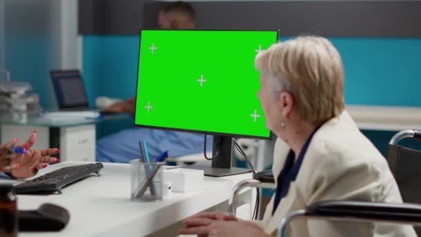 慢性损伤患者在显示器上看着绿色屏幕 分析检查时带有色键背景的孤立显示 轮椅上的妇女使用了模拟复制空间模板 — 图库视频影像