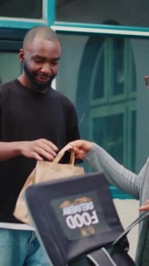 Dikey video: Afrikalı Amerikan kuryesi yanlış müşteriye restoran yemeği getiriyor, adam da kadın çalışana bunun benim emrim olmadığını söylüyor. Servis elemanı hazır yemek siparişinde sorun yaşıyor.