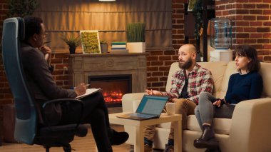 Erkek terapist, terapi seansında evli çiftleri dinliyor, ilişki hakkında konuşmak için psikoterapi randevusuna gidiyor. Psikoloji terapisi danışmanlığı yapıyorum. Üçayak atışı.