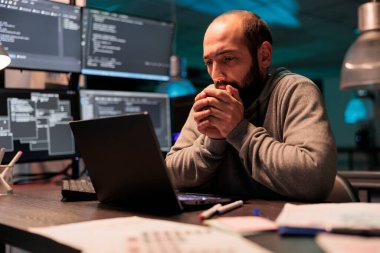 Geliştirici soğuk hissediyor ve kahve içiyor, sıcak içeceği gece geç saatlerde ofiste ısınmak için kullanıyor. Kafein içeceği ve yeni kullanıcı arayüzü programlama hizmeti veren erkek kodlayıcı.