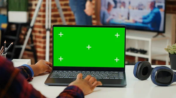 アフリカ系アメリカ人の従業員は ノートパソコンの緑のテンプレートで作業し 空白のコピースペースの背景を使用しています マネージャは 独立したクロマキーを分析し 机の上にコンピュータ上で表示をモック — ストック写真
