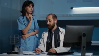 Sağlık ve hemşire, hastane muayenesi sırasında saatlerce sağlık tedavisinde çalışan hastalık belirtilerini inceleyen hasta raporlarını inceliyor. İlaç hizmeti ve konsept