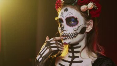 Stüdyoda Noel Baba 'yı düşünen korkunç genç bir yetişkin. Ölü Meksika bayramında düşünceli ve düşünceli davranıyor. Kutsal süvari Catrina cadılar bayramı tanrıçasını canlandıran kadın. El kamerasıyla..