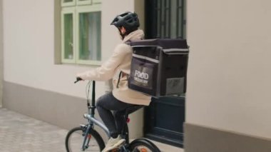 Afro-Amerikan kadınına paket yemek siparişi veren fast food teslimatçısı. Ön kapıya kağıt torba getiren. Kadın kurye hazır yemek, hızlı yemek servisi..