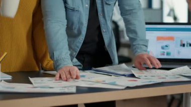 İş arkadaşlarının satış tabloları ve masa başında anahtar kâr göstergeleriyle iş belgelerini gözden geçirmesine özen göster. Pazarlama istatistiklerini karşılaştıran ve strateji üzerinde çalışan meslektaşların ayrıntılı görünümü.