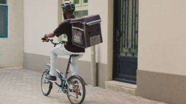 Servis elemanı müşteriye öğle yemeği siparişi veriyor, erkek kadına restoran yemeğiyle kağıt torba veriyor. Gülümseyen Afro-Amerikan müşteri dışarıda hazır yemek yiyor..