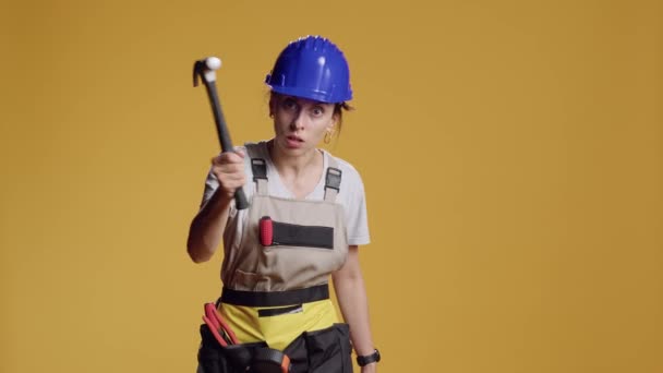 被赋予权力的女建筑工人在镜头前拿着铁锤表现出危险的形象 威胁要打工具和生气 拿着大锤的暴躁好斗的女人 — 图库视频影像