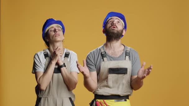 建筑工人的画像 戴着硬礼帽和工作服 做祷告手势 祈求帮助 希望解决问题 努力改造和建设 — 图库视频影像