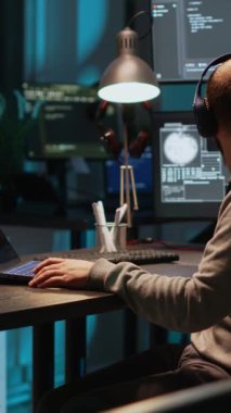 Dikey video: Bilgisayar üzerinde çoklu monitörlü programlama kodu yazan yazılım mühendisi, terminal penceresinde html betiği ile çalışıyor. Algoritmalar ve çevrimiçi bulut hesaplamaları gece geç saatlerde geliştiriliyor.