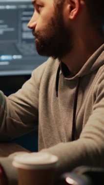 Dikey video: Ofiste fikirler, programlama senaryosu ve kaynak kodları üzerinde kafa yoran düşünceli bilişim mühendisi. Düşünceli adam kodlama çözümünü düşünüyor, gece geç saatlerde html dili ile uygulama geliştiriyor..