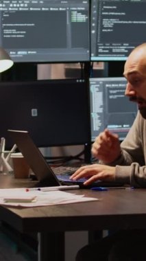 Dikey video: Genç adam yorgun hissediyor ve programlama kodu üzerinde çalışıyor, veritabanı bilgisini ve dizüstü bilgisayarına html betiği yazıyor. Yetişkin ofiste uyuyakalıyor, terminal penceresini kullanmaktan yoruluyor.