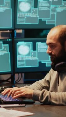 Dikey video: Bilgi yok etmek için sunucuyu hackleyen siber dolandırıcı, bilgisayar ve birden fazla ekranla kurumsal veri ağına sızıyor. Veritabanını hacklemeye ve sistem verilerini çalmaya çalışıyorum, siber saldırı.