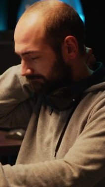 Dikey video: Yazılım geliştiricisi omurilik rahatsızlığı ile ilgileniyor ve sunucu programlama üzerinde çalışıyor, ofiste oturuyor. Sırt ağrısı ve kodlama veritabanı sisteminden muzdarip, stresli erkek kodlayıcı.