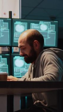 Dikey video: Genç adam sunucu arayüzünü kırmak için şifreyi kırıyor, virüsü kullanarak bilgisayarı ele geçiriyor ve bilgi çalıyor. Sistemin veritabanında siber saldırı yapan tehlikeli ve gizemli bir hacker.