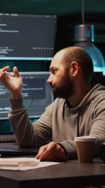 Dikey video: Web mühendisi programlama çözümü hakkında düşünüyor, kaynak kodu bulmak ve uygulama geliştirmek için yeni fikirler üretiyor. Düşünceli ve düşünceli olmak, bulut hesaplama yapay zekası üzerinde çalışmak. El bilgisayarı