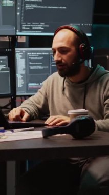 Dikey video: Bilgisayardaki çevrimiçi video konferansına katılan yazılım geliştiricisi, html betiği programlıyor ve uzaktan telekonferansta konuşuyor. Web kamerasında sohbet etmek için video konferans toplantısı kullanılıyor