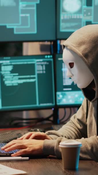 垂直视频 带面具黑客攻击数据库服务器的网络恐怖分子 带头罩黑客攻击计算机系统的黑客和激活病毒以创建恶意软件的网络恐怖分子 骗子偷窃大数据 泄露信息 — 图库视频影像