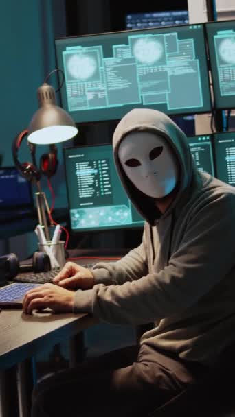 垂直录像 男性罪犯带着面具和头罩侵入计算机系统 闯入公司服务器窃取大数据 戴面具的人看上去很危险 很可怕 他在制造安全软件 — 图库视频影像