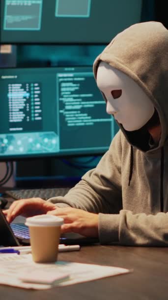垂直视频 带有掩码黑客数据库服务器的It盗窃者程序员 带有掩码黑客攻击计算机系统的黑客和激活病毒以创建恶意软件 骗子偷窃大数据 泄露信息 — 图库视频影像
