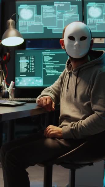 垂直视频 戴面具的网络恐怖分子黑客攻击数据库服务器 带有头罩的黑客侵入计算机系统并激活病毒以制造恶意软件 神秘的冒充者偷窃大数据 — 图库视频影像