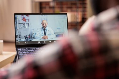 Bilgisayardaki teletıp görüntülerine katılan adam doktorla tele-sağlık ve uzaktan video konferans danışmanlığı hakkında konuşuyor. Web kamerasıyla çevrimiçi telekonferans yapmak, uzaktan konuşmak..