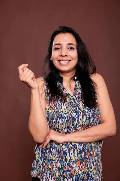 明るいインドの女性の肖像画笑って笑みを浮かべて 幸せな女性の手を保持し 指をスナップ折り畳まれた ケアフリー人ポーズフロントビュースタジオ中出し上の茶色の背景 — ストック写真