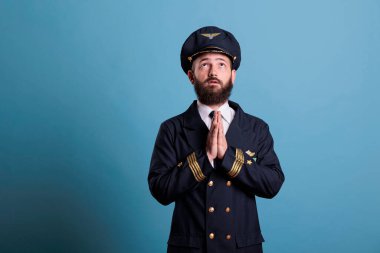 Üniformalı bir yüzbaşı tanrılara dua ediyor, yukarı bakıyor, elleri bağlı duruyor. Dini uçak pilotu memnun, havacı uçuştan önce ibadet ediyor, övgüler yağdırıyor.