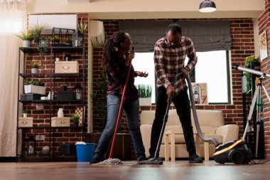 Afro-Amerikalı çift ev temizliğinde eğleniyor, şarkı söylüyor, o anın tadını çıkarıyor. Elinde elektrikli süpürgeyle gülen koca ve karısı paspasla heyecanla şarkı söylüyor..