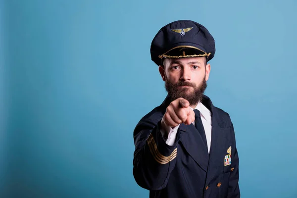 本格的な航空機のアビエイターの指でカメラを指して 航空アカデミーのパイロットの訓練の募集 エアクルーの制服と帽子フロントビューの肖像画を身に着けている自信のある指 — ストック写真