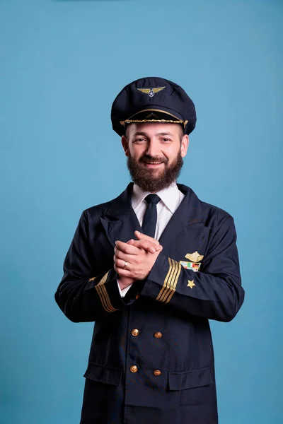 stock image Smiling excited plane pilot in professional uniform clapping hands. Happy positive airlane captain applauding, shaking palms, standing, looking at camera, studio medium shot